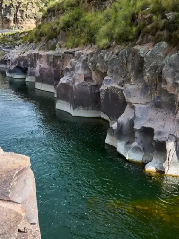 Vista panorámica Garganta del Diablo (Experiencia Extrema), caída de agua rodeada de acantilados en entorno andino.